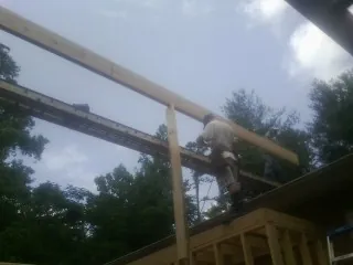 Carpenter setting a ridge beam over a new addition frame — Ice Dam Removal by Roofing Brothers in Lost Nation