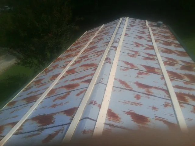 Rusted metal roof panels with new wood purlins before replacement — Storm Damage Roof Repair in Lost Nation by Roofing Brothers