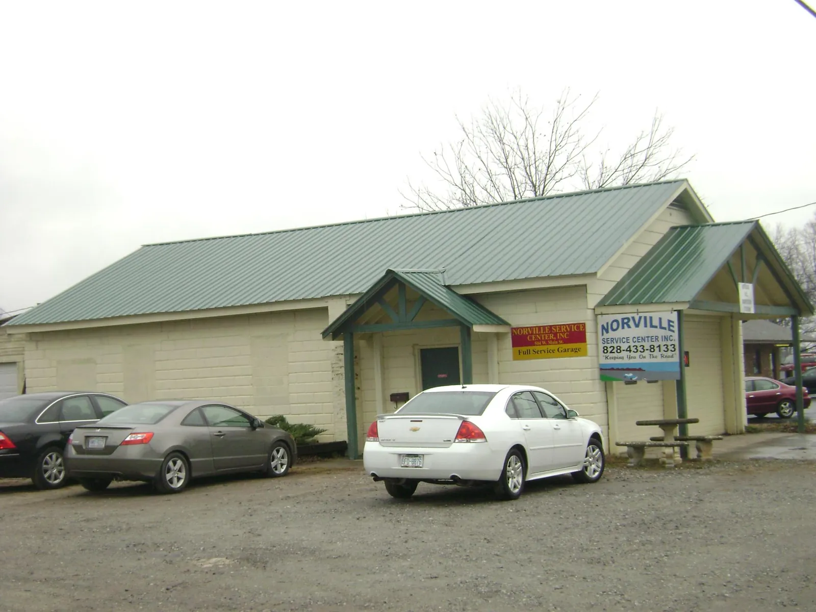 Green metal roof on a service garage with a covered entry in Lost Nation